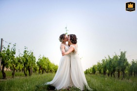 Bride and bride sharing a kiss in the middle of the vineyards in Jarnac, France.
